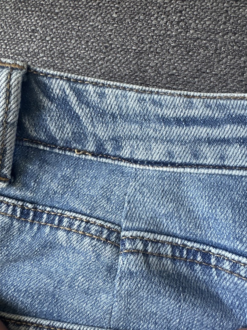 Close-up van een herstelde denimzoom met dubbel stiksel